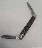 Knife fully opened in V shape showing both blades and handle texture
