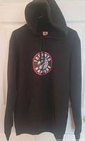 Full view of black Toronto Raptors hoodie on hanger