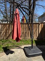 Full view of red cantilever umbrella on square base