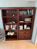 Two of the three wall unit sections side-by-side, showcasing shelving and cabinet door design
