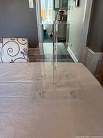 Side view of clear acrylic stand showing central rod and tiers