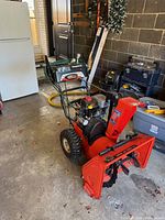 Front-left view of snowblower showing auger housing, chute, and engine