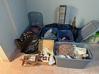 Overview of multiple totes, bags and boxes with assorted Christmas decorations