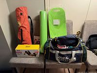 All items on chairs: duffel with tubes, yoga mat, foam pad, orange carry bag, thigh toner box