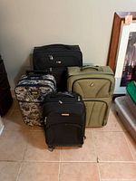 Front view of all four suitcases showing sizes, colours and condition