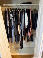 Full closet view showing entire lot of hanging women’s clothing