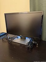 Front view of Dell SE2417HGX monitor on stand with cables