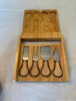 Box open showing four cheese tools in molded tray