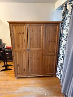 Front view of three-door pine wardrobe