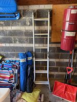 Full view of folded ladder leaning against wall