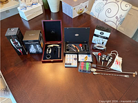 Full lot of boxed and loose barware items on table