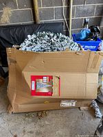 Crushed original box containing flocked pop-up Christmas tree