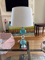 Full view of lamp with shade on glass table