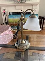 Full view of brass-tone table lamp showing base, stem, shade, and cord