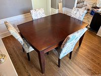 overall view of wood table with four patterned chairs