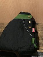folded black and green coveralls front view
