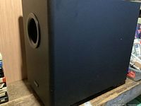 Full view of black Denon subwoofer showing side port
