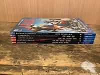 Spines of five DC Comics graphic novels stacked