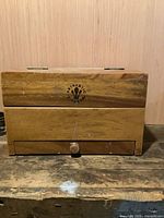 Front view of hardwood utensil box showing logo and drawer knob