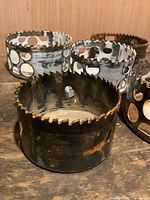 Group of four hole saw bits showing tooth condition and side holes