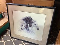 Full view of framed horse print in black frame