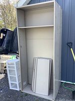 Full view of tall grey metal shelving unit with shelf panels
