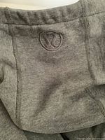 Close-up of grey fleece sweatpants waistband showing embroidered Lululemon logo
