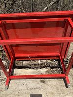 Underside view of red metal table frame