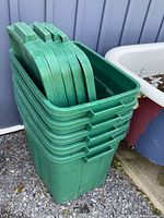 Stack of five green Rubbermaid Roughneck totes with lids inside