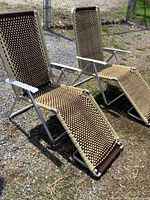 Two reclining lawn chairs side by side showing full view