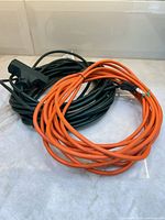 Coiled orange and green extension cords on countertop