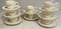 Eight demitasse cup and saucer sets stacked to show complete quantity and matching pattern