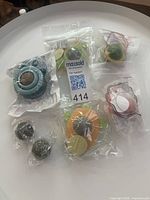 Five sealed packages containing catnip ball holders, two loose replacement balls and adhesive pads