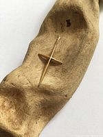 Front view of 10K gold cross pendant on wood display