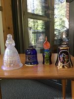 Four glass bells side by side on table