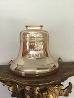 Front view of iridescent carnival glass Liberty Bell piggy bank showing BANK text