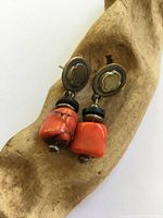 Front view showing red coral beads, brass caps, oval silver-tone tops