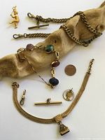 Group shot of all gold-tone jewelry pieces on white background
