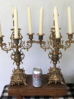 Full view of both brass candelabra with candles for scale