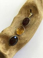 Front view showing three faceted amber stones in silver settings