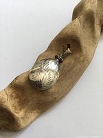 Front view of sterling silver engraved oval perfume bottle pendant