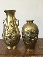 Front view of both brass vases showing relief designs