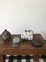 Group shot of four Chinese curios on wooden surface