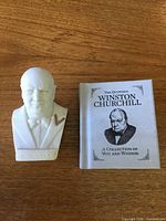 Front view of alabaster Winston Churchill bust beside miniature book
