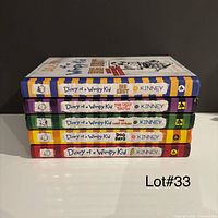 Stack of six Wimpy Kid hardcovers showing spines and cover of Do-It-Yourself Book