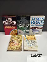 Front view of all five hardcover novels standing and lying flat showing titles and cover art