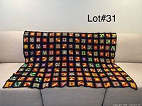 Blanket draped over sofa showing full front pattern