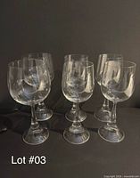 Six stemmed goblets grouped on dark background, entire lot visible