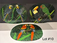 Three oval placemats with different tropical bird prints