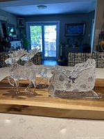 Full view of clear acrylic sleigh and two reindeer on wood board